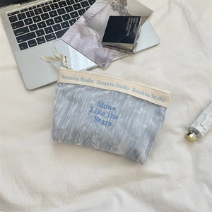 Dettaglio ravvicinato della borsa in velluto blu con ricamo 'Shine Like the Stars'