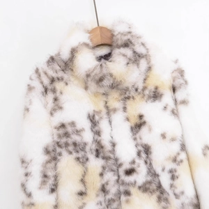 Faux fur jacket with brown spotted pattern on wooden hanger against white background