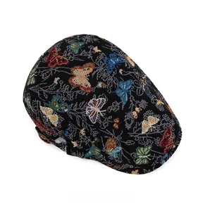 Detail der farbenfrohen Schmetterlingsstickerei auf schwarzer Jacquard-Baskenmütze