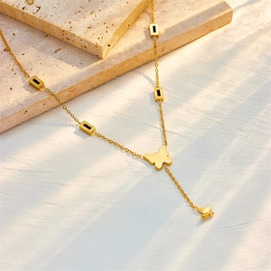 Gold Y-shaped butterfly pendant necklace with small black square accents on stone