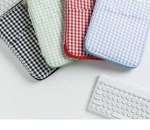 Flat lay of colorful gingham padded laptop sleeves for iPad with zipper closure