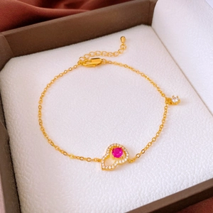 Détail du bracelet plaqué or avec gemme en cœur rouge et fermoir mousqueton robuste