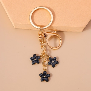 Detail of gold keychain with three dark blue enamel flower charms and lobster clasp