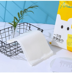 Detail of white waffle texture disposable pet towel in a black wire basket for travel