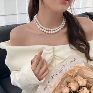Close-up of elegant double-layered pearl necklace worn on neck with retro French style