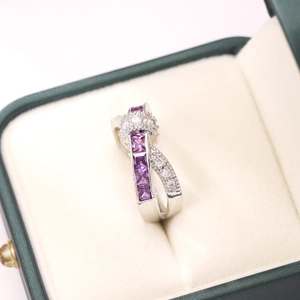 Macro view of crossover ring with purple princess cut stones and white zircon accents