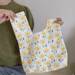 Close-up of floral cotton canvas wrist bag with yellow flower patterns and green stems