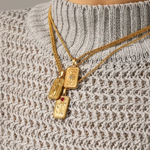 Gold Tarot necklaces featuring The Star and Sun pendants on a grey knitted sweater