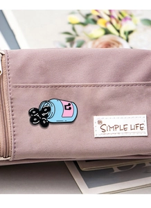 Enamel bottle pin with music note on pink canvas bag for creative fashion accent