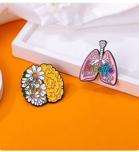 Detailed close-up of colorful enamel pins featuring creative brain and lung organ designs