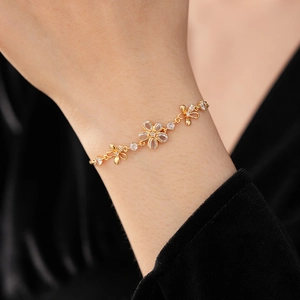 Gros plan détaillé d'un bracelet fleur doré avec zircons porté au poignet d'un mannequin
