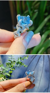 Close-up of square-cut light blue stone and chain-link diamond ring band detail