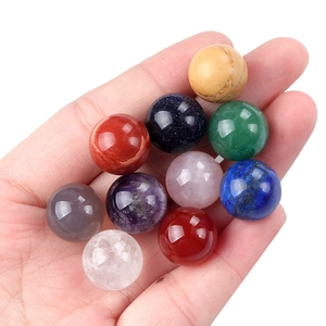 Handheld variety of 14mm polished natural crystal and agate gemstone spheres in mixed colors