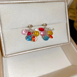 Macro shot of silver needle earrings with vibrant colorful resin beads in a jewelry box