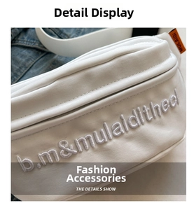 Close-up of white canvas chest bag featuring letter embroidery and orange woven label