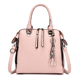 Pink woven leather handbag detail with golden cat tassel pendant and crossbody strap