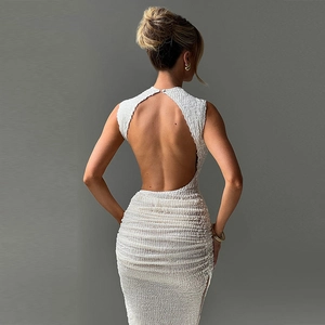 Detail of white textured dress showing open back design and ribbed fabric on a model