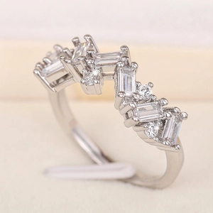 Close-up of silver ring with baguette and round zircons on a white velvet display