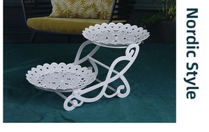 Macro detail of white double-tier dessert stand with elegant lace-hollowed metal trays