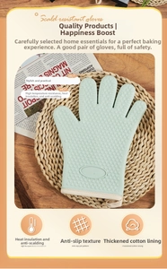 Close-up of mint green silicone oven mitt showing heart anti-slip texture and cotton lining