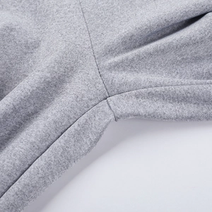 Detail-Makroansicht der grauen Strickstruktur und der hochwertigen Doppelnadel-Nähtechnik