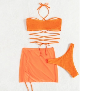 Flat lay detail of orange three-piece bikini set with seersucker fabric and mesh skirt