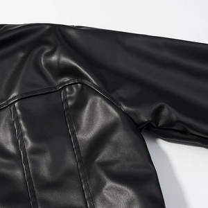 Macro view of matte black faux leather jacket showing lychee grain texture and stitching