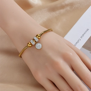 Elegant gold snake chain bracelet with sparkling rhinestones worn by a model on silk
