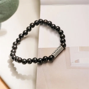 Détail d'un bracelet en perles de bois naturel 6mm avec entretoise en métal ciselé gothique