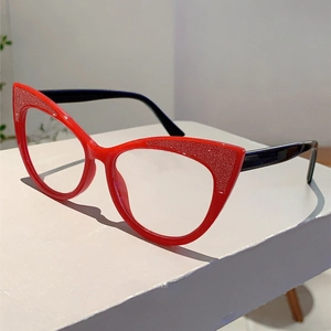 Detail of red cat-eye frame glasses with silver glitter accents and black temples