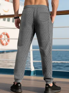 Detail view of men's grey jogger pants showing jacquard rhombus texture and ribbed cuffs