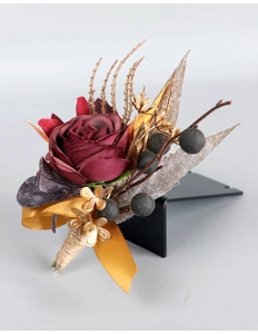 Detail eines Vintage Hochzeits-Ansteckstraußes mit burgunderroter Rose und Goldband