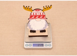 Weight measurement of a wooden Christmas gnome ornament on a digital scale showing 21.9g