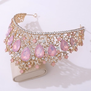 Detailed view of luxury gold crown with pink teardrop crystals and sparkling rhinestones