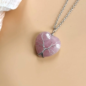 Detail of pink crystal heart pendant with silver wire-wrapped tree of life design
