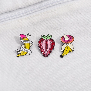 Creative enamel fruit pins set featuring strawberry and banana designs on canvas bag