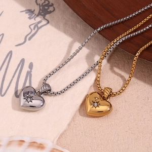 Detail of heart pendants with star-set zircon in gold and silver on box chains