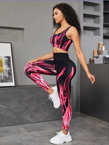 Detail of high-stretch seamless gradient yoga set with pink flame print on black fabric