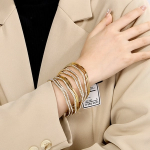Macro detail of layered wave bangle featuring gold plating and shimmering pavé crystals