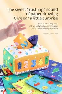 Detail showing baby hands interacting with a plush tissue box toy featuring rustling paper