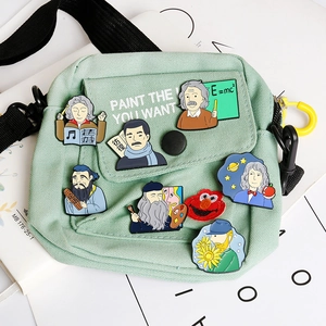 Detail of mint green canvas bag decorated with famous historical enamel pins and badges