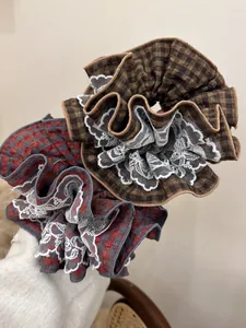 Detail of red and brown plaid scrunchies with white lace edges in a two-piece set