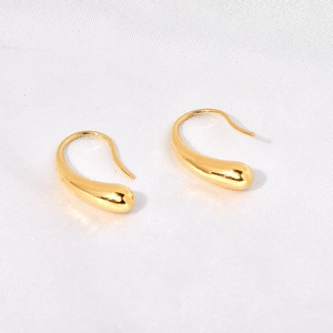 Polished 18K gold-plated stainless steel teardrop earrings displayed on white silk fabric