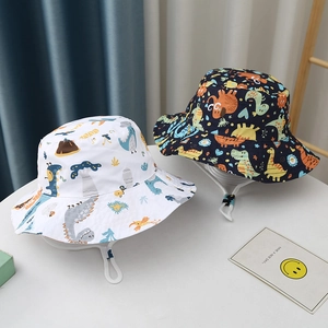 Detail of printed kids bucket hats in white and navy with dinosaur patterns and wind ropes