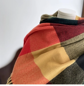 Detailed close-up of soft plaid scarf with vibrant colors and delicate fringe trim