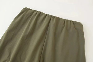 Détail du pantalon vert armée avec taille élastique et texture de tissu plissé