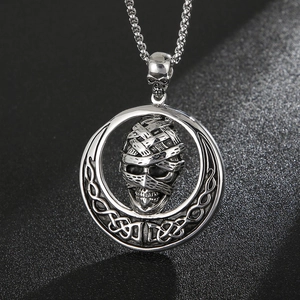 Detail of vintage silver titanium steel mummy skull pendant with gothic celtic knot