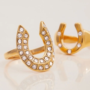 Classic 18K gold plated horseshoe U-ring with sparkling white diamonds on white surface