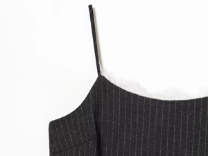 Dettaglio ravvicinato del top nero a righe sottili con pizzo bianco e cuciture