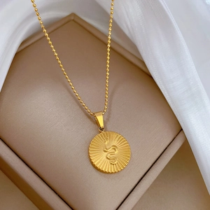 Minimalist gold titanium steel necklace with a snake relief round pendant on silk